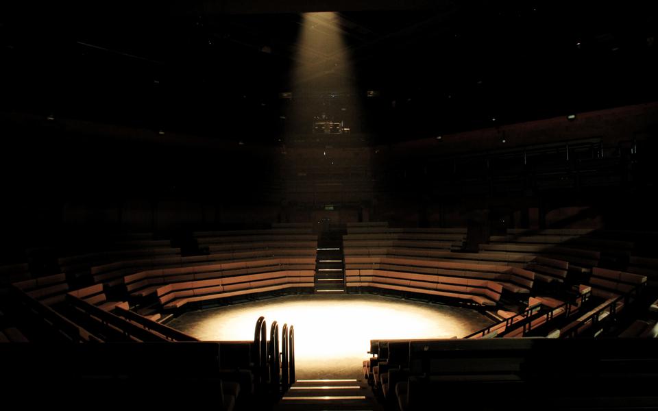 The Young Vic Main House auditorium in an in-the-round configuration, with a single spotlight on stage